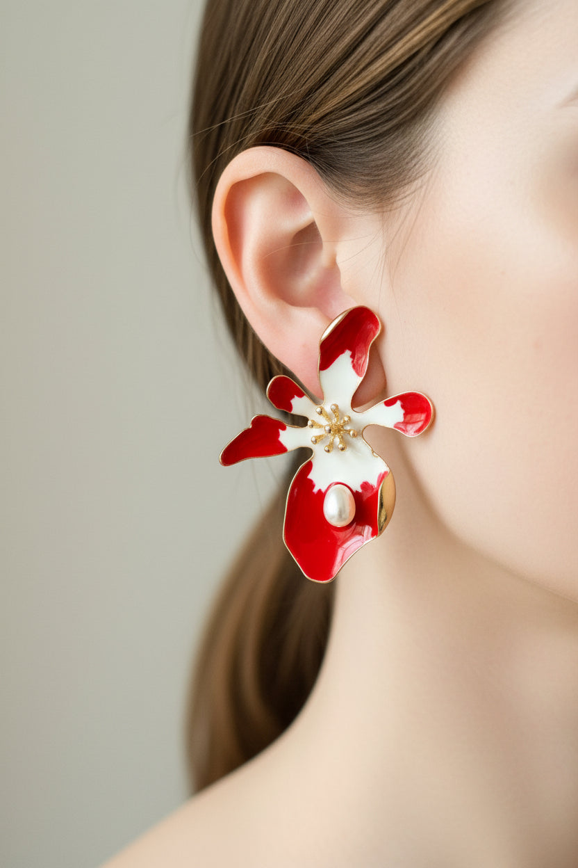 Red and white floral earrings on a white card with a gold accent, against a light gray background.