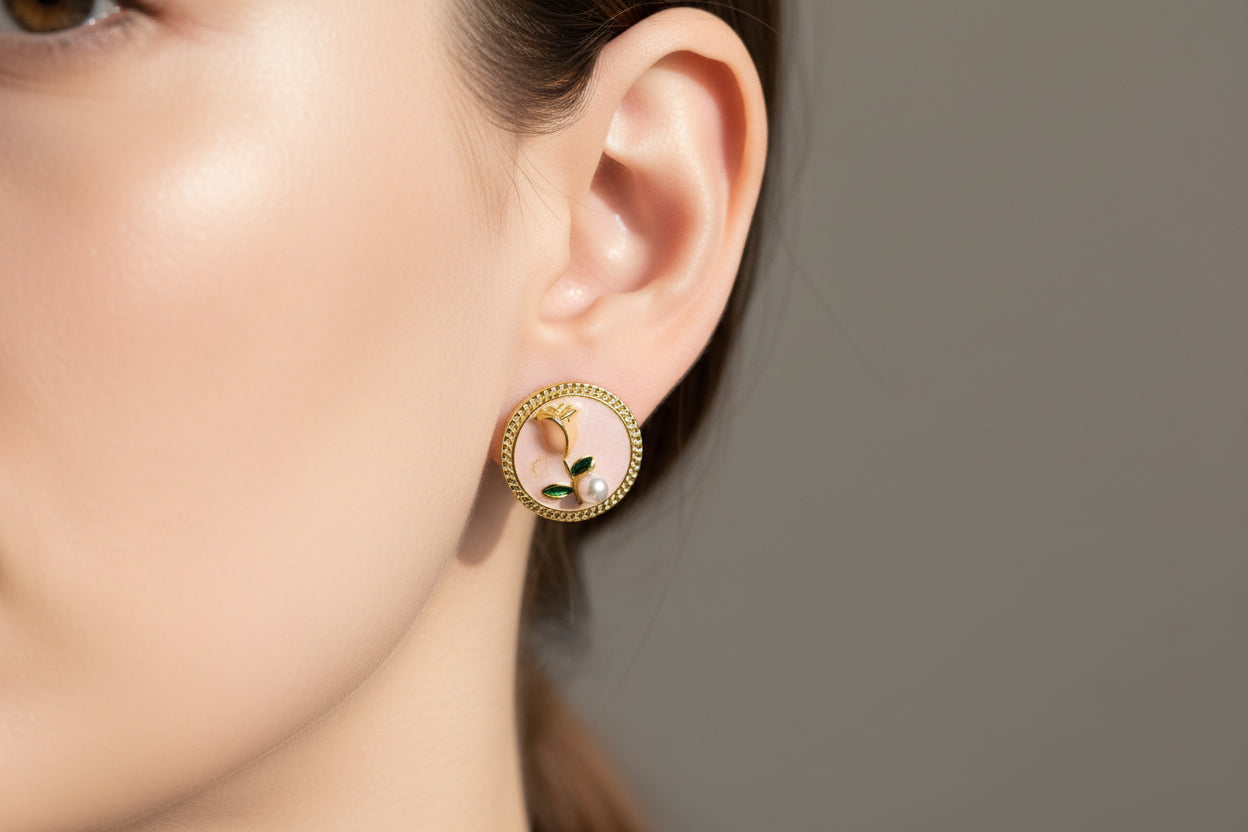 Pair of round earrings with floral design on a beige surface