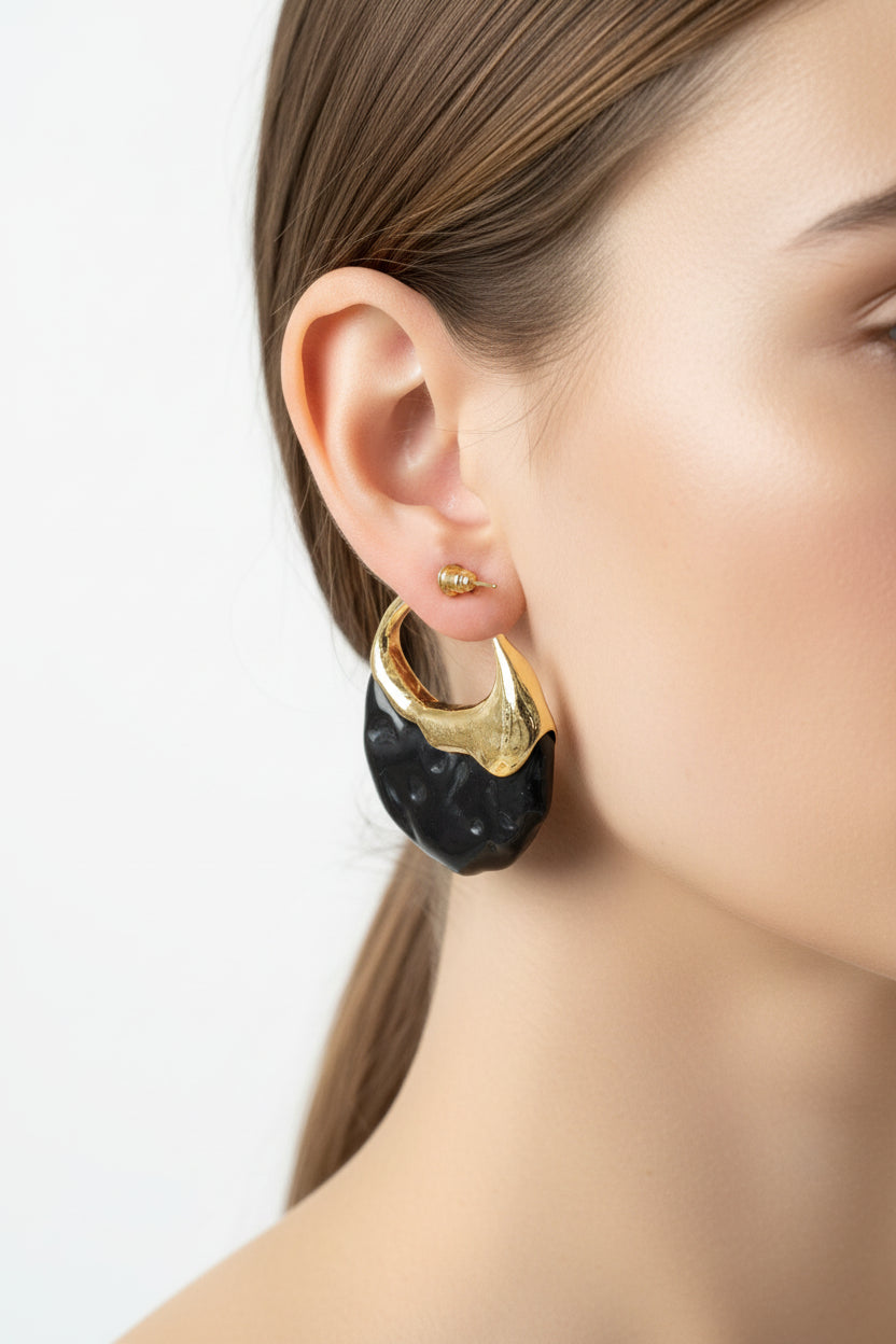Black and gold hoop earrings on a white background