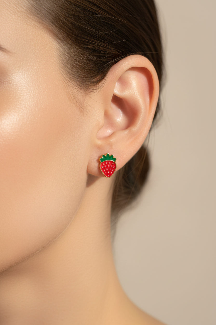 Watermelon-themed earrings on a textured surface